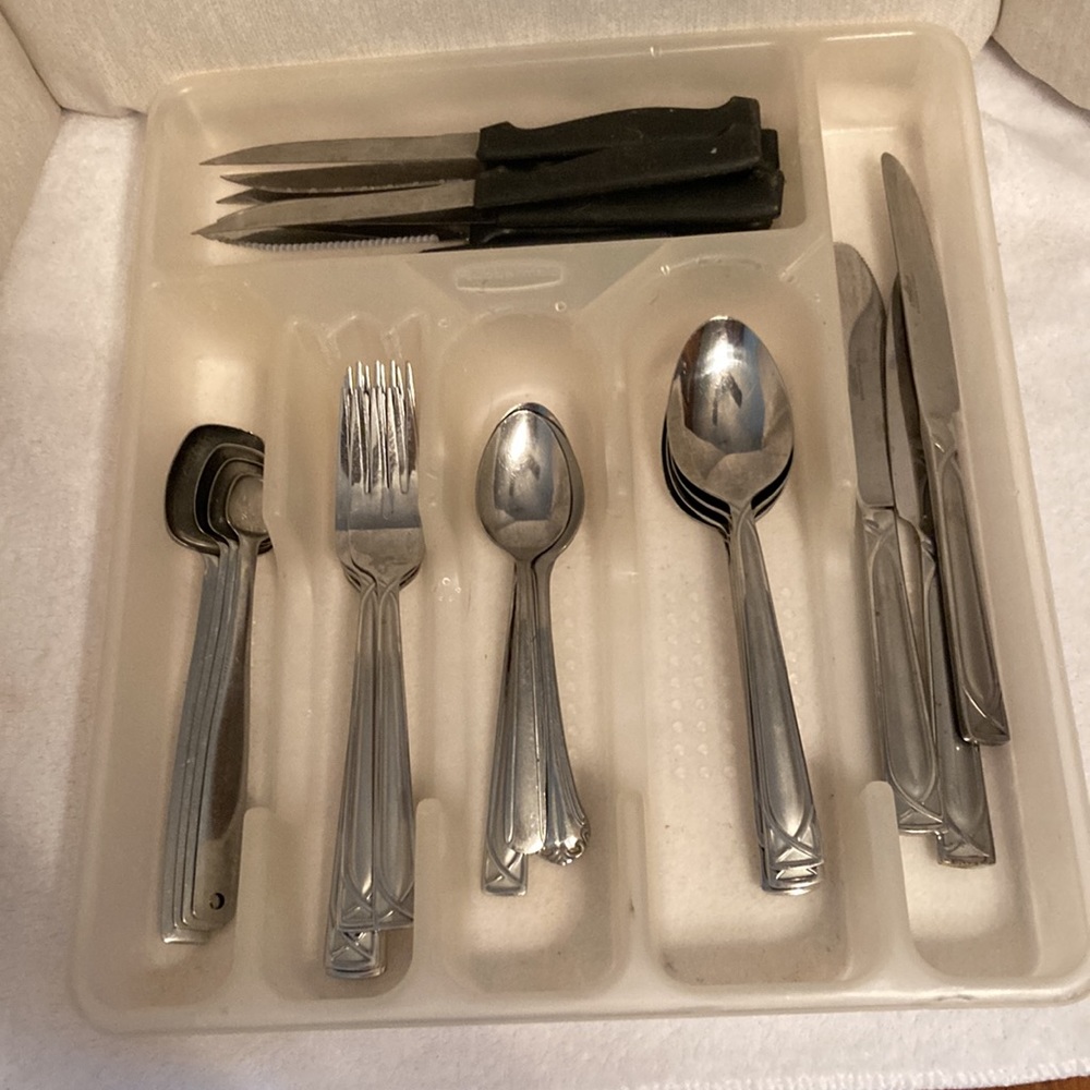 A dish holder with flat knives,sharp knives,spoons,forks & measuring spoons